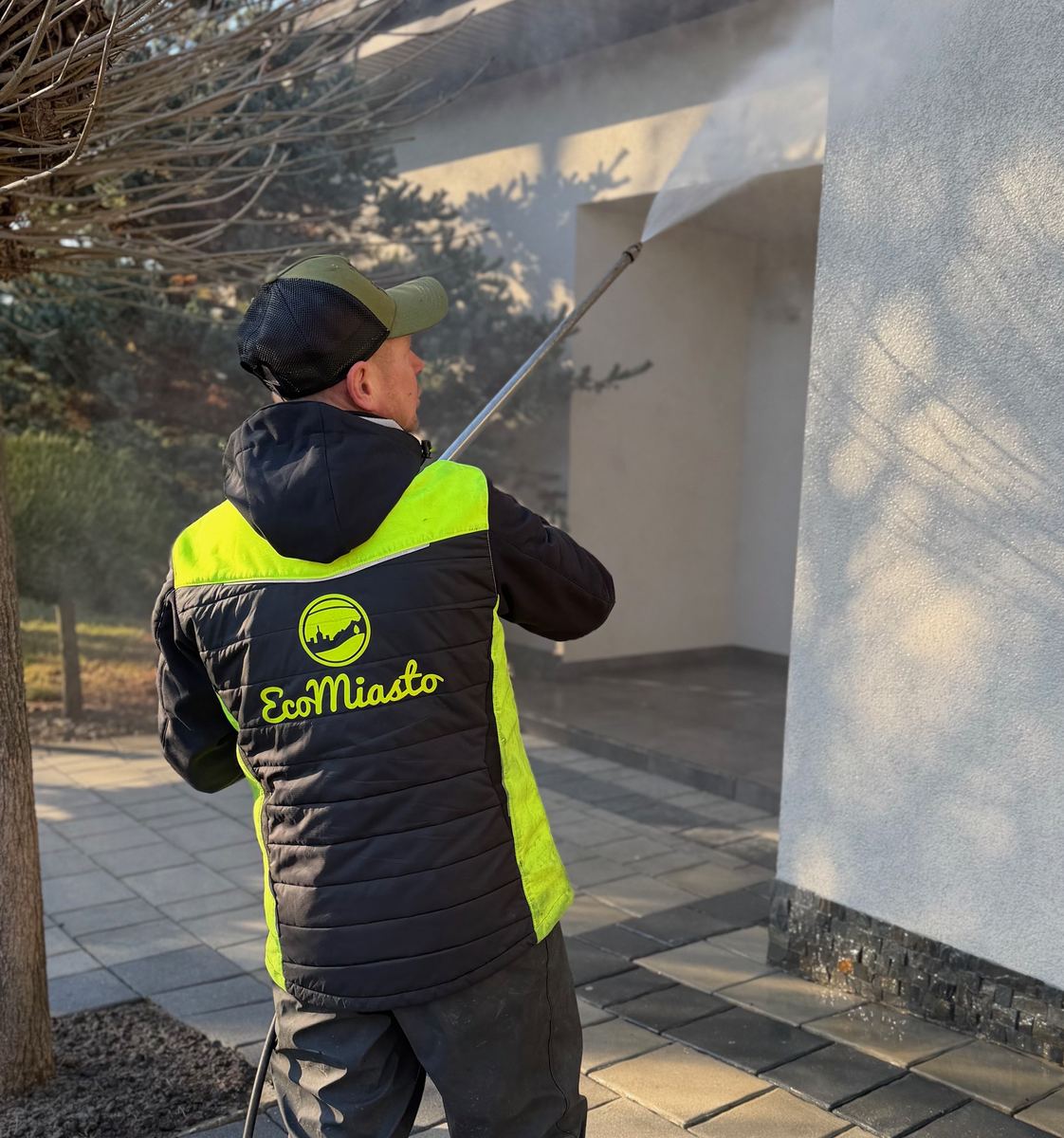 Czyszczenie elewacji — pracownik EcoMiasto myje ścianę